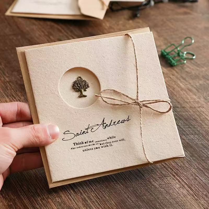 Vintage handmade greeting card with a bronze tree charm and jute twine bow, based on image_0d66c2.jpg. Elegant gift card with custom typography on textured kraft paper for luxury scented candle gift set.