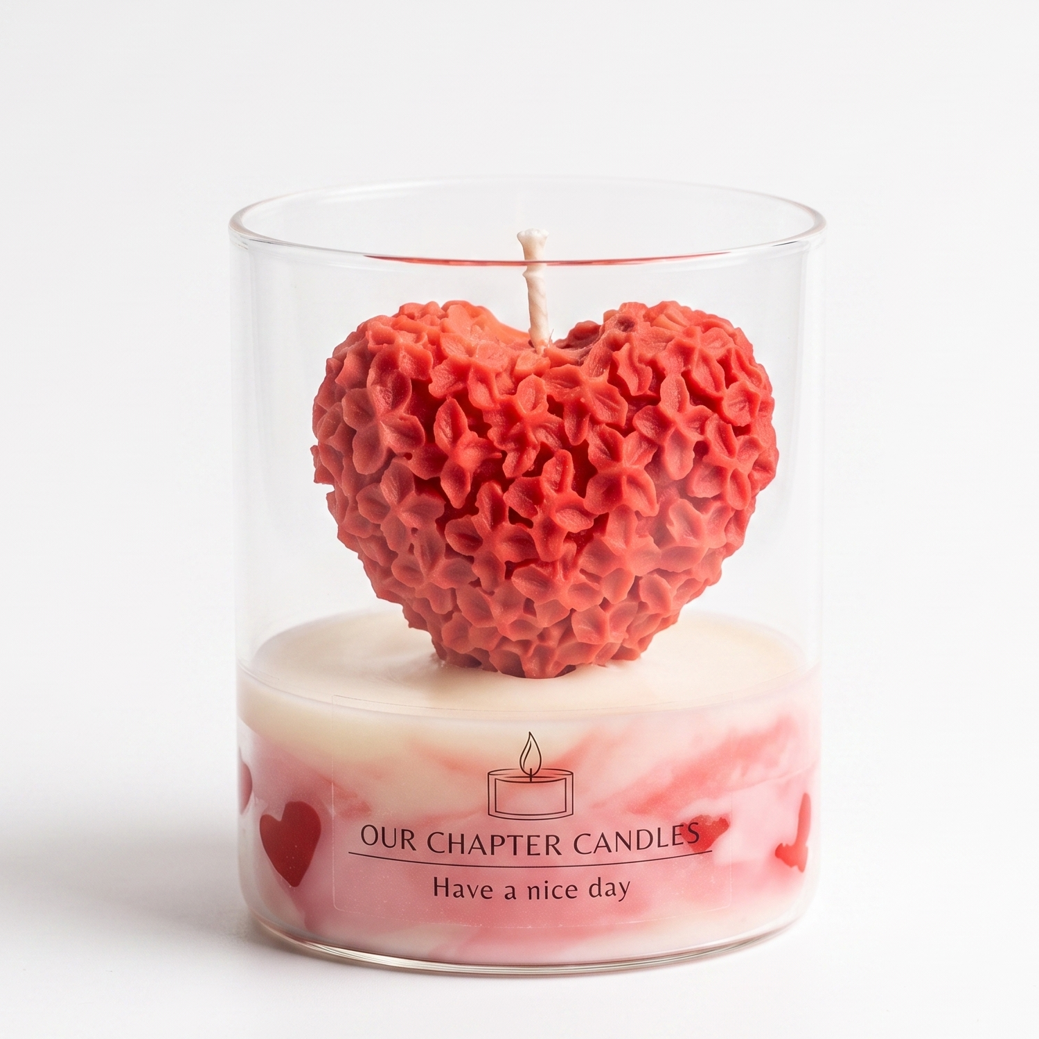 A luxury artisanal soy wax candle in a clear glass jar based on image_4635e2.jpg. Features a pink and white marbled wax base and a large, stunning red heart sculpture intricately carved with tiny lilac flowers on a pure white background.