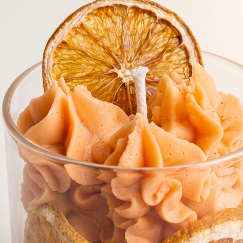 Extreme close-up macro shot of dehydrated orange slices and textured whipped soy wax peaks. High-resolution view showcasing the exquisite craftsmanship and fine details of a scented fruit candle.