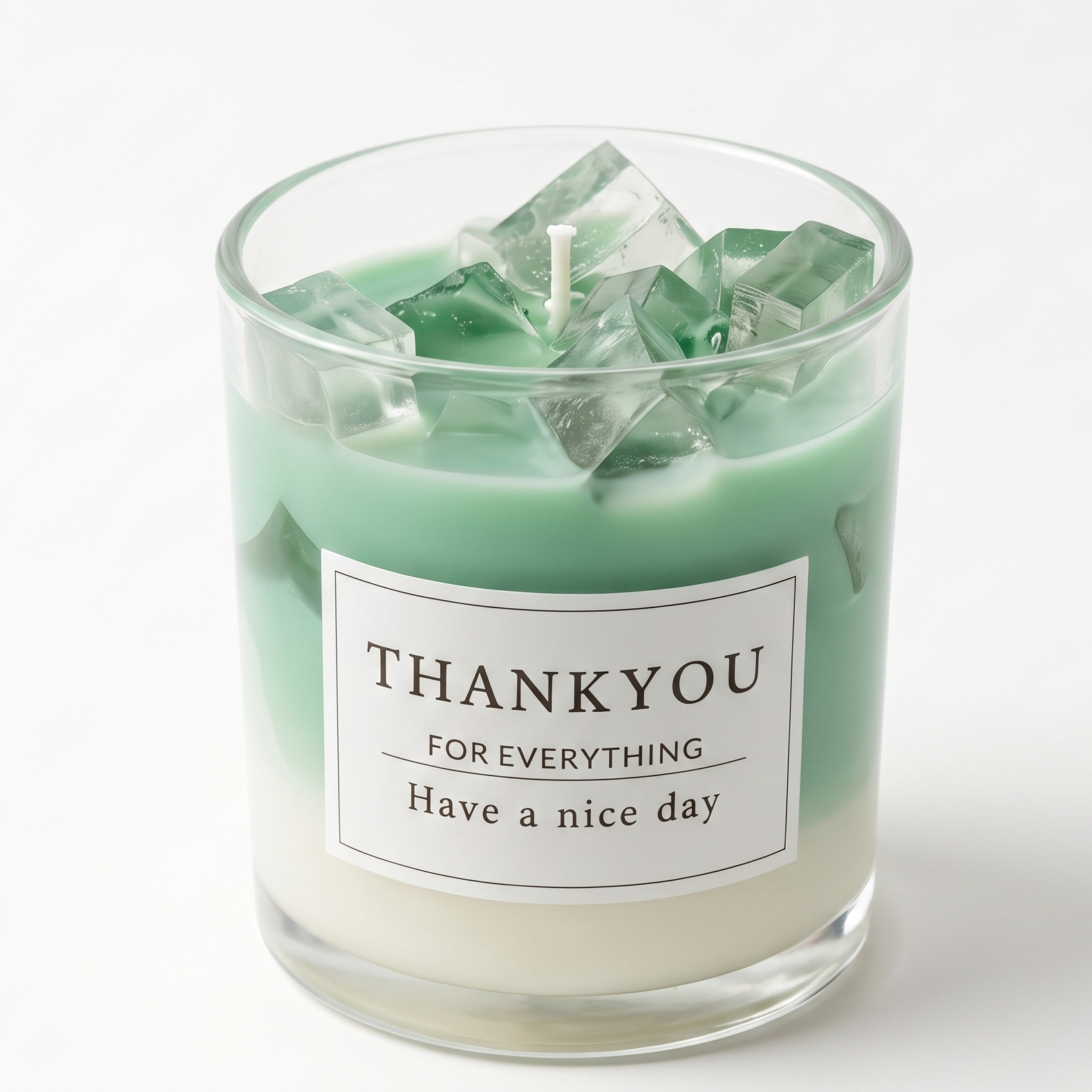 Aesthetic mint green drink-inspired soy wax candle in a clear glass jar topped with realistic clear gel wax ice cubes. Features a minimalist label reading "THANK YOU FOR EVERYTHING - Have a nice day" on a pure white background.