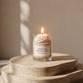 Serene aesthetic lifestyle setting featuring a lit colorful sprinkle jar candle on a minimalist beige table. Cozy and bright modern room decor, ideal for luxury sweet-scented aromatherapy gifting.
