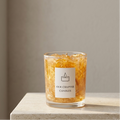 Serene aesthetic lifestyle setting featuring an unlit golden gel wax jar candle with gold foil on a minimalist limestone surface. Clean and bright modern room atmosphere with natural sunlight, perfect for elegant aromatherapy gifting.