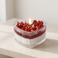 Serene aesthetic lifestyle setting featuring a lit heart-shaped pomegranate jar candle on a minimalist travertine table. Clean and bright modern room atmosphere, perfect for premium luxury Valentine's Day or anniversary gifting.