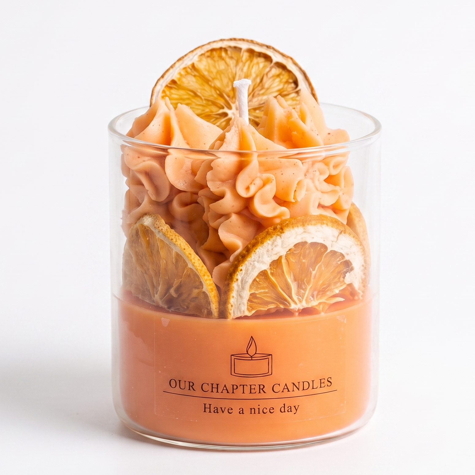 Luxury orange soy wax dessert candle in a clear glass jar topped with whipped wax and natural dried orange slices. Features the text "OUR CHAPTER CANDLES - Have a nice day" on a clean white background.