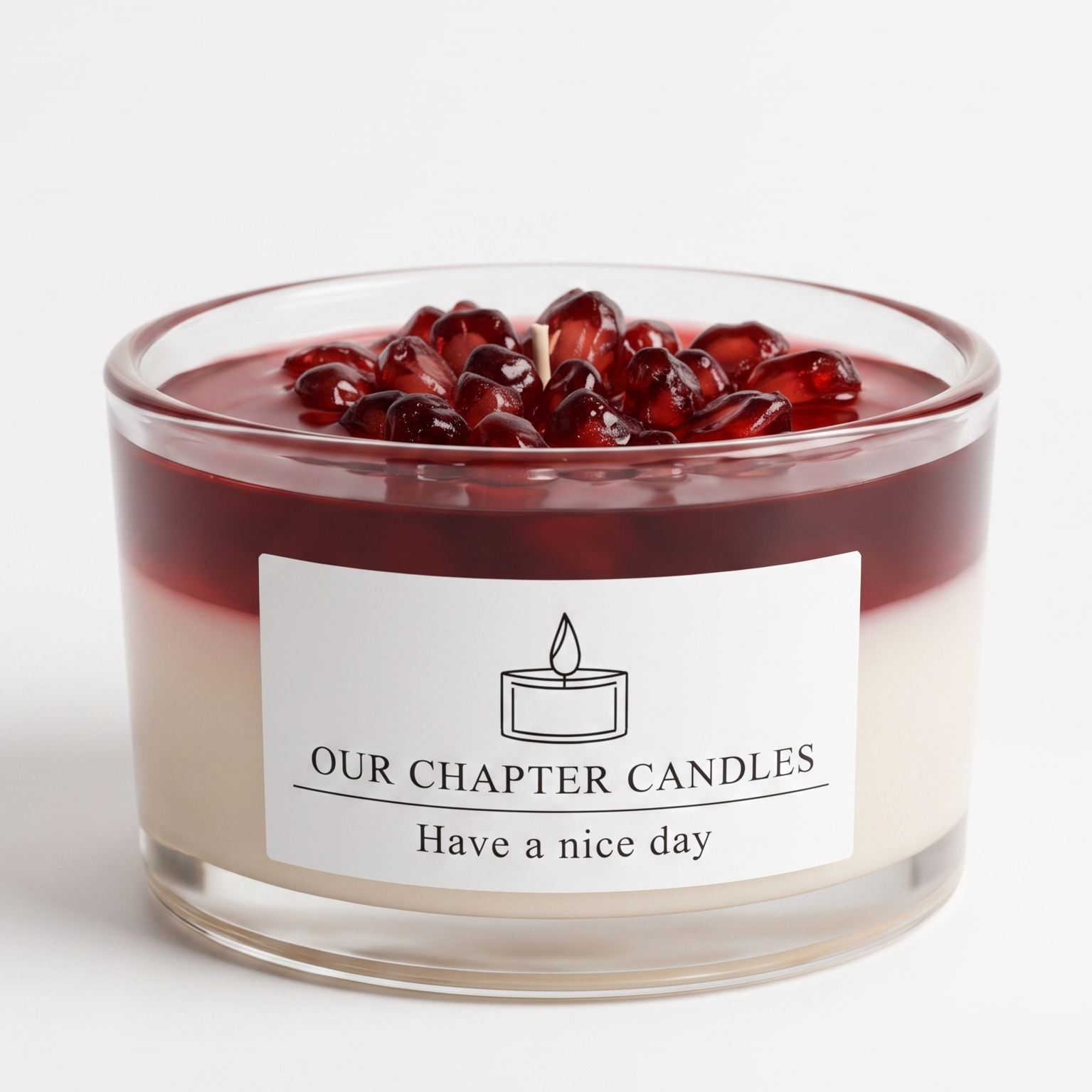 A luxury dual-layer pomegranate dessert soy and gel wax candle in a clear glass jar based on image_2a0a03.jpg. Features a solid cream white base, a crystal-clear deep red jelly layer, and a top pile of realistic ruby-red wax pomegranate seeds on a white background.